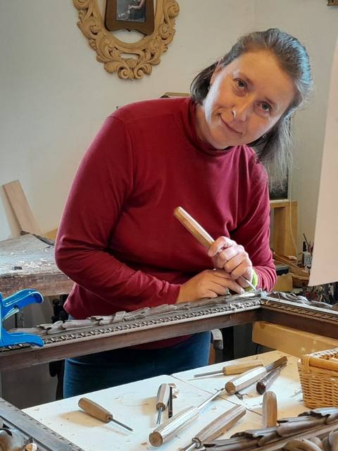 Ludmila bei der Arbeit an einem geschnitzten Rahmen