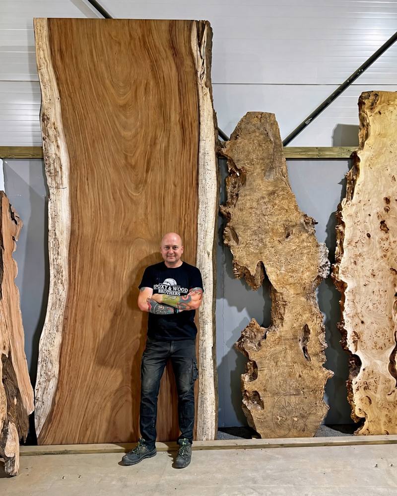 Miro neben einer grossen Holzbohle in der Werkstatt